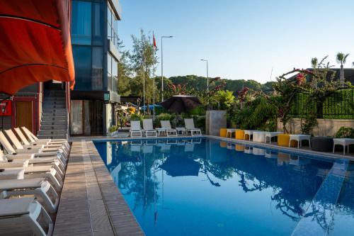 a swimming pool with lounge chairs next to a building at Velaris Boutıque Hotel in Belek