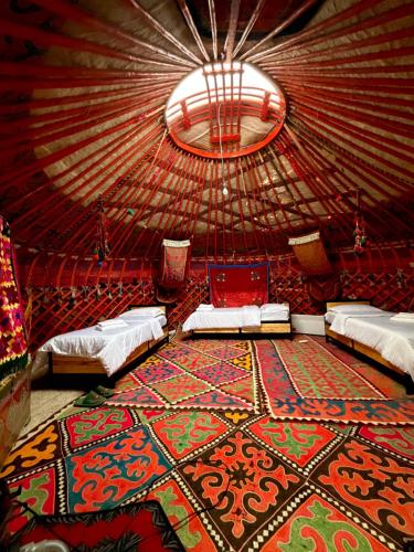 a large room with two beds and a large rug at Son kol Keng suu guesthouse in Keng-Suu