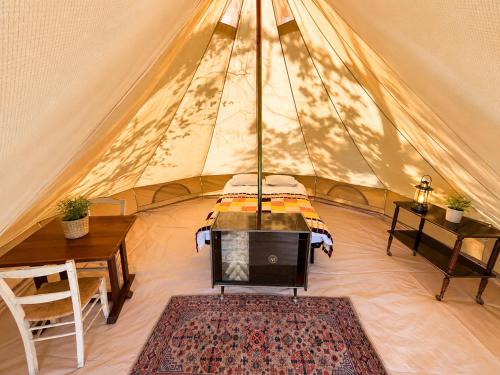 a tent with a table and a bed in it at Natur'O Médoc in Naujac-sur-Mer