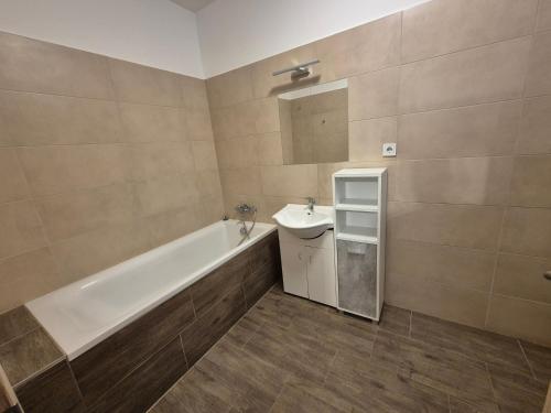 a bathroom with a tub and a sink and a bath tubermott at Riverside house Duna in Rajka