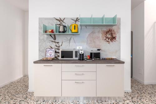 a white kitchen with a counter with a microwave at Il Nido Dei Ribelli in Mergo