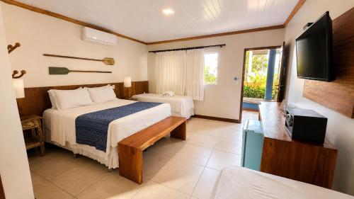 a hotel room with a bed and a tv at Pousada Alto da Vila Noronha by Alto da Ilha in Fernando de Noronha