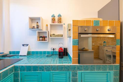 a kitchen with blue and orange tiles on the counter at Appartamento La Pelosa in Stintino