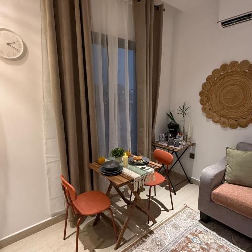 a living room with a table and chairs and a couch at Bali island Home2 in Al Khobar