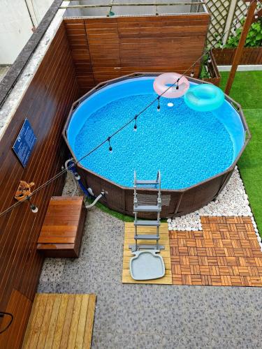 a large swimming pool with a table and a chair at Cabo da Vila Guesthouse in Ribeira Grande