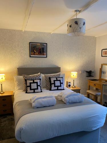 a bedroom with a large bed with pillows on it at Cobweb Cottage in Patrington