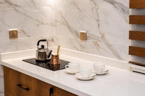 a tea kettle and cups on a counter in a bathroom at Diamond Motel in Baghdād