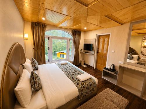 a bedroom with a large bed and a large window at Pahalgam Resort and Cottages in Pahalgām