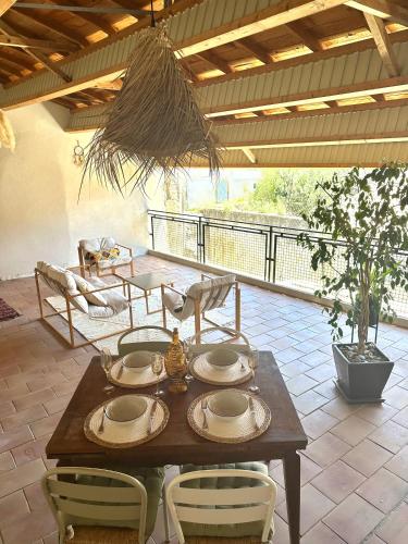 a wooden table with plates and chairs on a patio at Escapade provençale in Tarascon