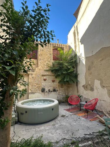 a courtyard with a tub and two chairs and a building at Escapade provençale in Tarascon