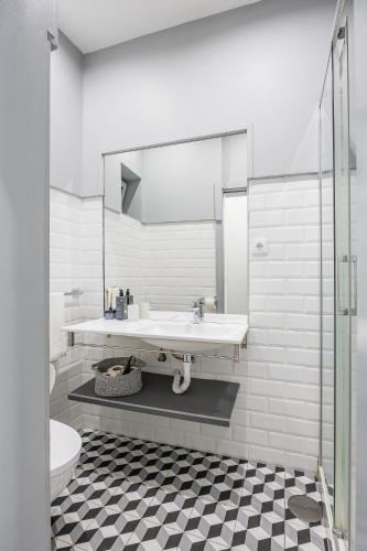 a white bathroom with a sink and a toilet at A Lodge in Blue in Aveiro