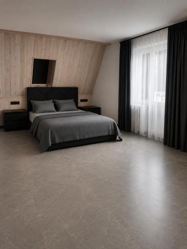 a bedroom with a bed and a large window at Graphite House in Kyiv