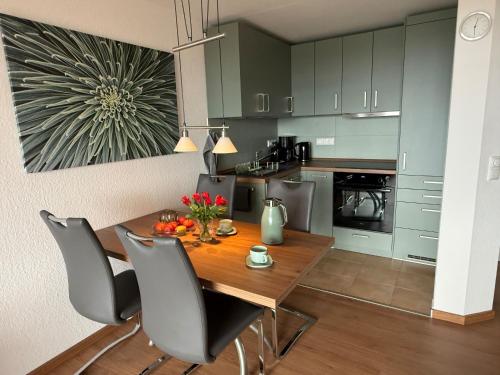 a kitchen with a dining room table and chairs at Ferienwohnung De Kraan in Dorum-Neufeld