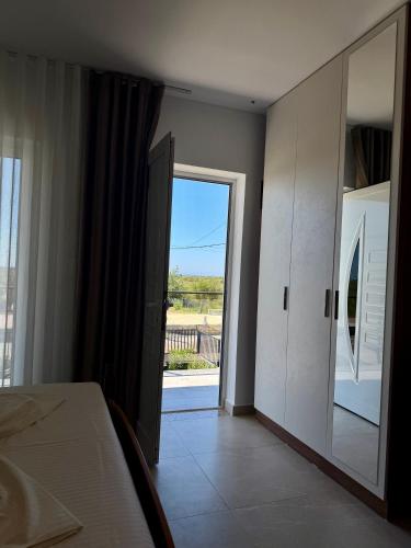 a bedroom with a door leading to a balcony at Villa 3 in Velipojë