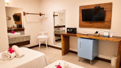 a hotel room with a bathroom with a tv on a wall at Pousada Alto da Vila Noronha by Alto da Ilha in Fernando de Noronha