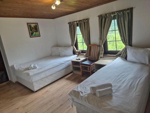 a bedroom with two beds and a desk with a chair at Къща Цачеви in Tryavna
