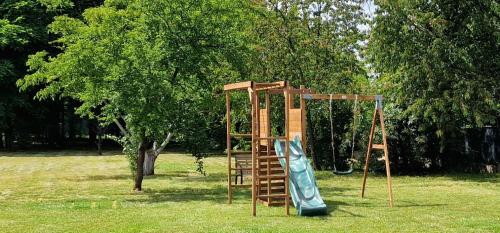 a wooden playground with a slide and a ladder at HYDE PARK APARTMENTS in Čakovec