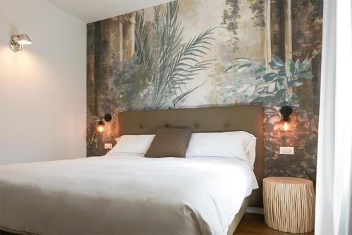 a bedroom with a white bed with a painting on the wall at Hotel B&B il Mosaico in Sirmione