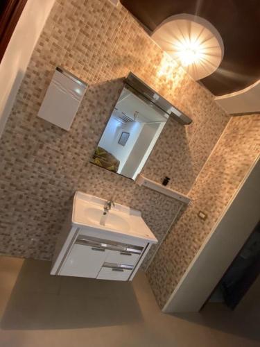 a bathroom with a sink and a mirror at Ain grenz in Kelibia