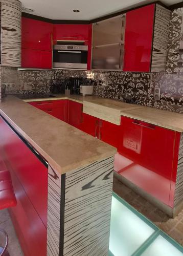 a kitchen with red cabinets and a counter top at Appartement l'Ariondaz in Courchevel