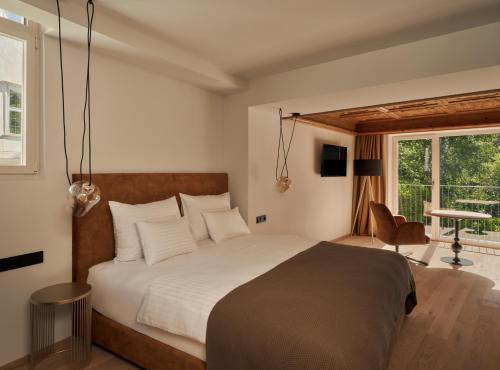 a bedroom with a bed and a desk and a window at Villa Giacomuzzi in Bolzano