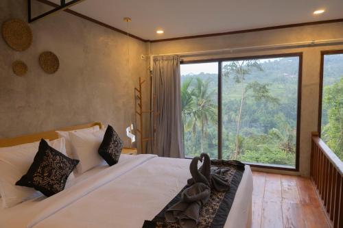 a bedroom with a large bed with a large window at The Beauty Riptide in Karangasem