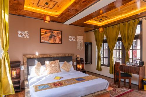 a bedroom with a bed and a desk and windows at RWACHO Hostel The Base in Leh