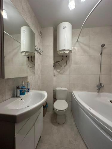 a bathroom with a toilet and a tub and a sink at квартира in Odesa