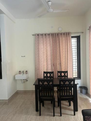 a dining room with a table and chairs and a window at Sai VVR homestay in Chennai
