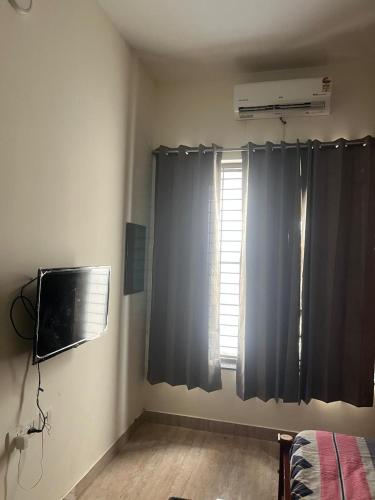a room with a window with a television and a windowictericter at Sai VVR homestay in Chennai