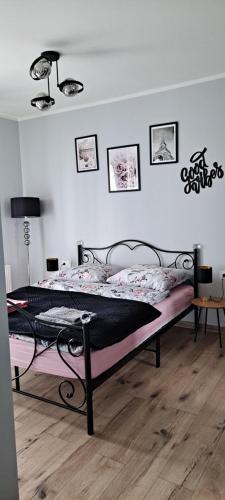 a bedroom with a bed with a black frame at Apartament Różowa Perła in Przemyśl