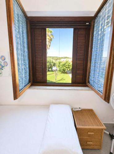 a bedroom with a window with a bed and a table at Leoncorno la Marina a Villasimius in Villasimius