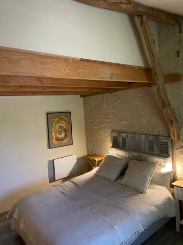 a bedroom with a large bed and a stone wall at gîte chêne doré in Ribérac