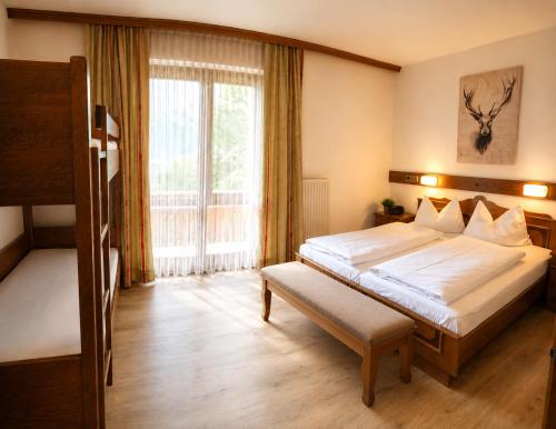 a bedroom with a large bed and a window at Ferienhof Alte Post in Weissbriach