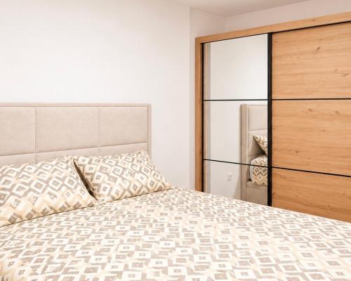 a bedroom with a bed and a dresser at Teslić CITY Apartment in Teslić