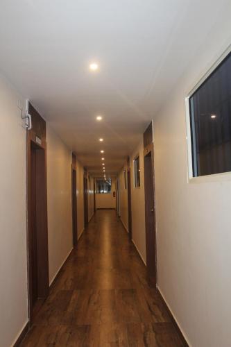 an empty hallway with a long hall with a window at Hotel Relax inn in Chikmagalūr