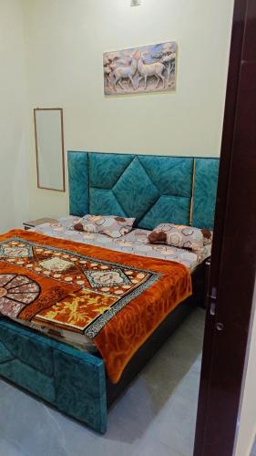 a bedroom with a large bed with a blue head board at Everspring Suites in Rohtak