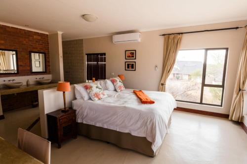 a bedroom with a bed and a window and a sink at Sweet Zebula in Mabula