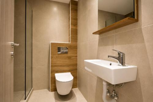 a bathroom with a toilet and a sink and a shower at Jason Apartments in Paralia Katerinis