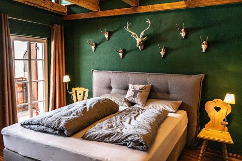 a bedroom with a bed with deer heads on the wall at Säntisblick in Oberstaufen