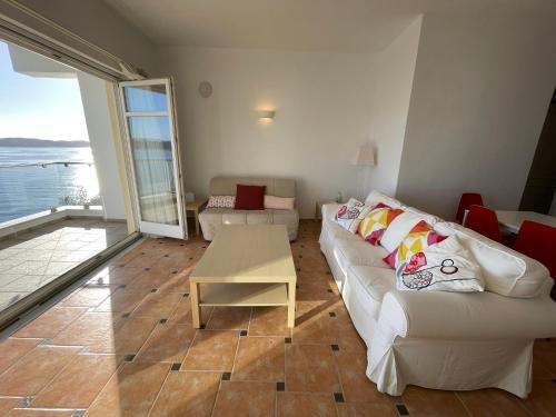 a living room with a white couch and a table at Gaia Skiathos Apartments in Achladies