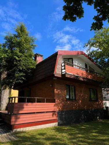 a red brick house with a balcony on top of it at Lake&Forest&City in Riga