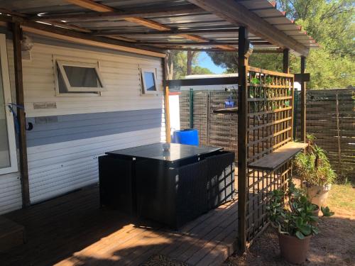 a screened in deck with a pergola at Mobilhome à Fréjus à 15 minute de la mer sur terrain indépendant in Fréjus