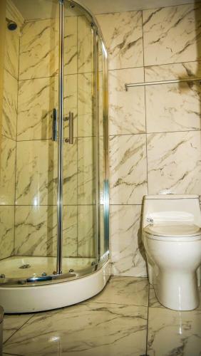 a bathroom with a toilet and a glass shower at Mirador wayras in Cuzco