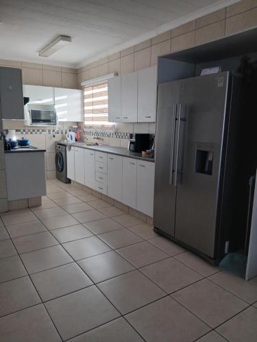 a large kitchen with a stainless steel refrigerator at Cousy Corner in Roodepoort