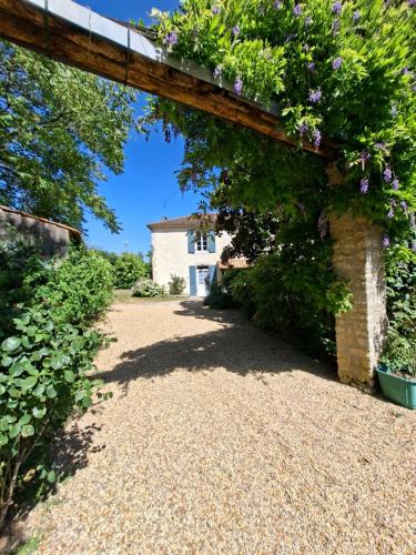 an archway leading to a house with flowers at La Glycine, Maison au calme avec jardin, Fibre Wi-Fi, 20 min des plages, Parking privé in Luçon