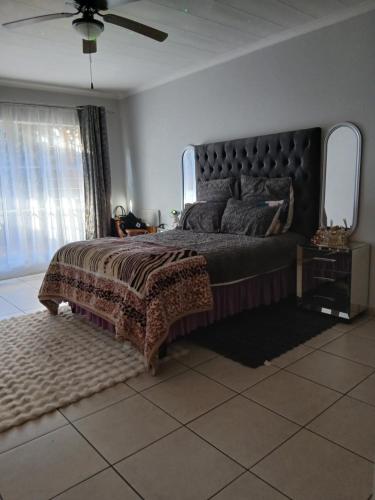a bedroom with a large bed with a large window at Cousy Corner in Roodepoort