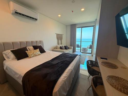 a bedroom with a large bed with a view of the ocean at Edificio Reserva del Mar Bello Horizonte in Playa Bello Horizonte