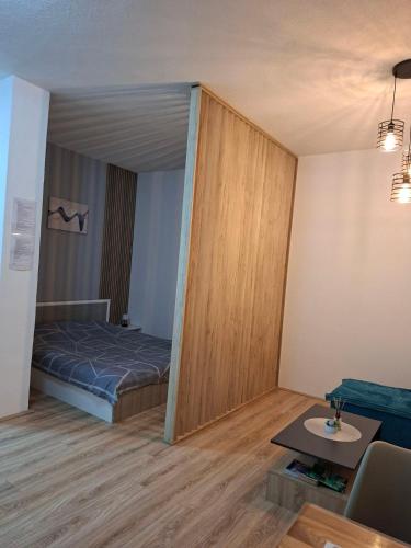 a small room with a bed and a table at M & A Apartmani in Kumanovo