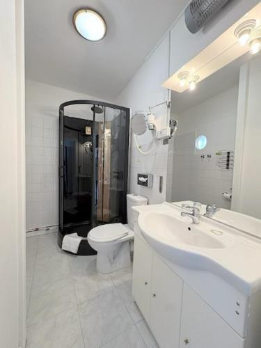 a bathroom with a shower and a toilet and a sink at Hôtel L'Univers in Châtellerault